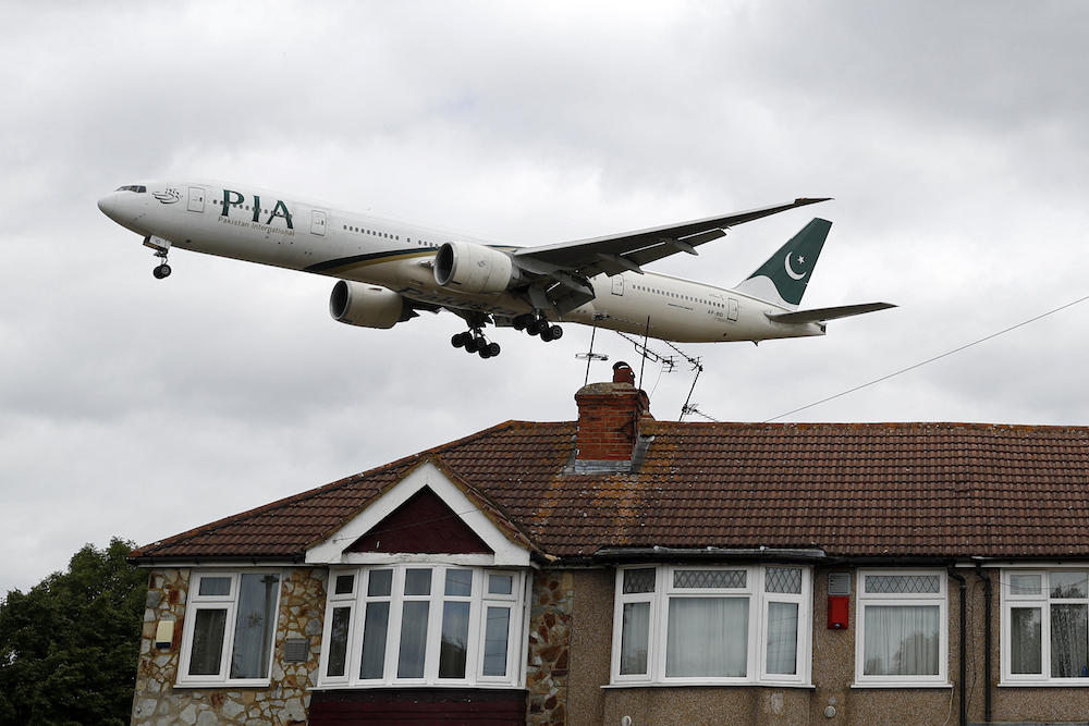 A Pakistan International Airlines aircraft comes in over houses to land at Heathrow on June 8, 2020. (AFP)