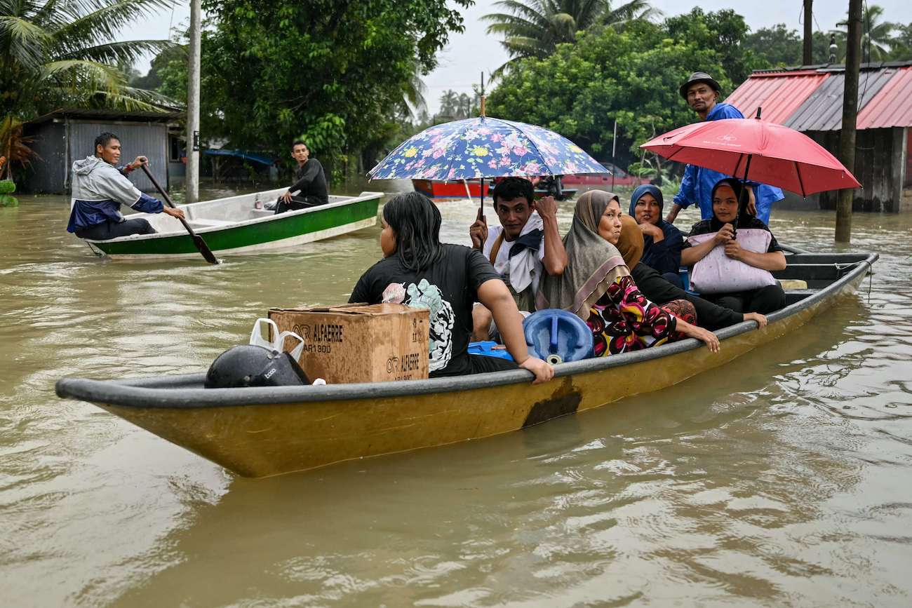 Residents are transported on boats through flood water after days of heavy rain in Tumpat in Malaysia’s Kelantan state on Nov. 30, 2024. (AFP)