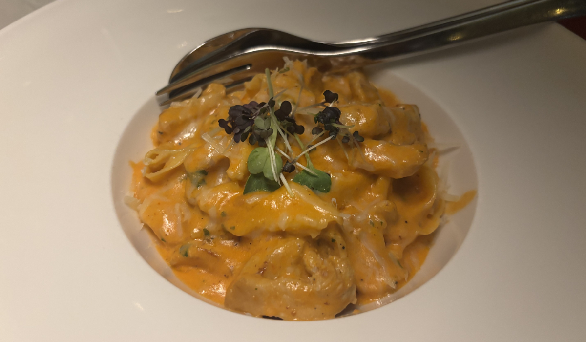 A comforting bowl of Pappardelle with Chicken, featuring handmade pasta in a rich tomato-cream sauce, garnished with fresh parsley and microgreens. (AN photo by Waad Hussain)