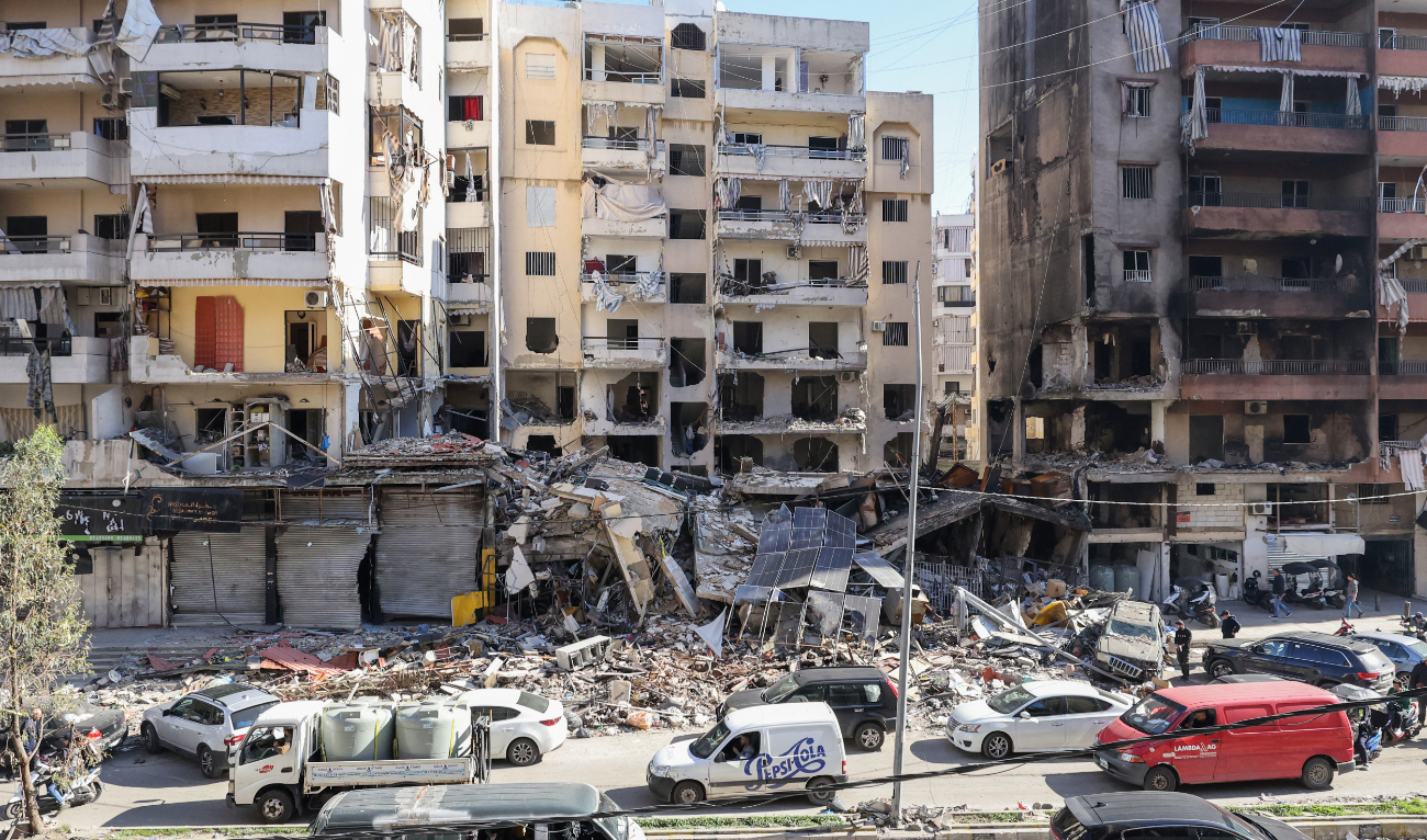 Cars drive past buildings that were damaged or destroyed in Israeli strikes in Beirut's southern suburbs Hay El-Sellom neighbourhood on December 2, 2024. (AFP)