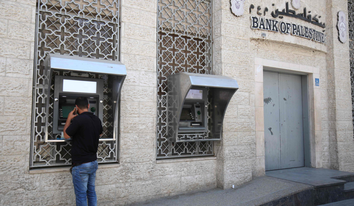 A man withdraws cash from an ATM machine at Bank of Palestine in Khan Younis in the southern Gaza Strip on May 15, 2018. (AFP)