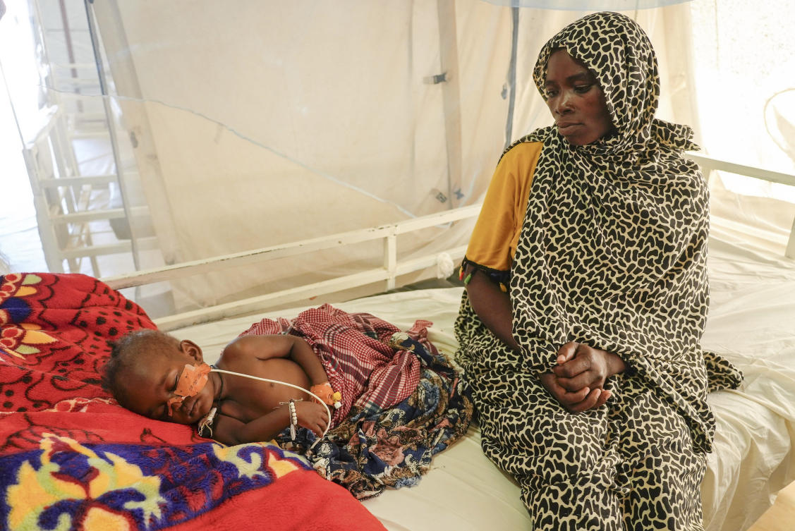 Khadiga Omer adam sits by her sick child in an MSF-run clinic in the Aboutengue displacement site near Acre, Chad, Friday, Oct 4. 2024. (AP)