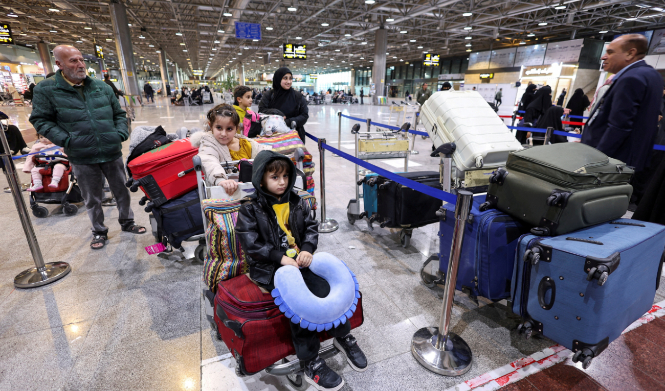 Displaced Lebanese, who had fled to Iraq, stand in a queue at Najaf airport as they prepare to head back home after a ceasefire between Israel and Hezbollah took effect. (Reuters)