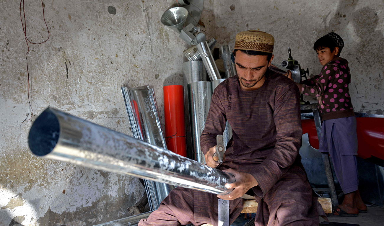 An Afghan man forges traditional tin stoves at a workshop in Kandahar on December 4, 2024. (AFP)