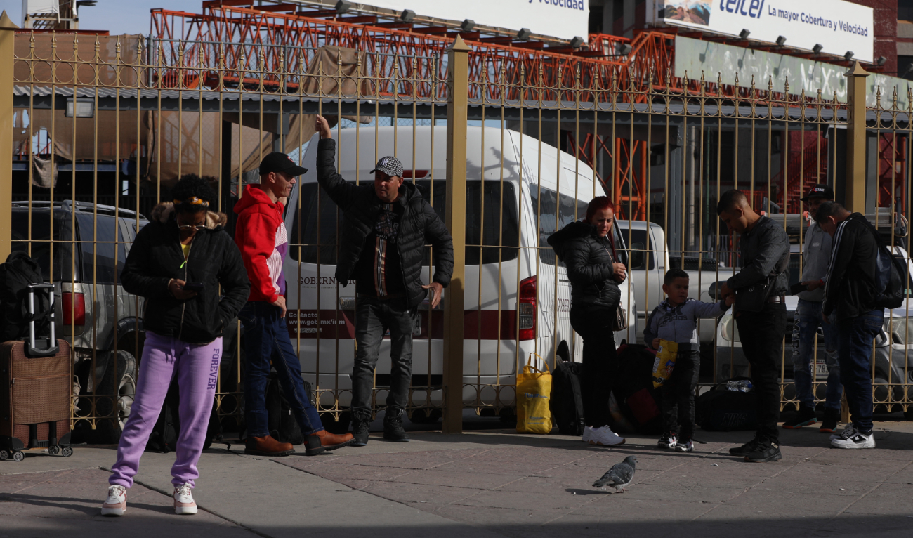 A group of migrants seeking asylum in the United States through the CBP One digital application wait in line near the Paso del Norte international bridge in Ciudad Juarez, Chihuahua State, Mexico, on November 28, 2024. (AFP/File)