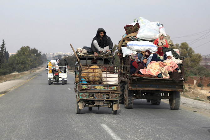 Syrians ride on a vehicle with their belongings in Hama on December 6, 2024, after rebels led by the Islamist group Hayat Tahrir Al-Sham (HTS) took control of the city. (AFP)