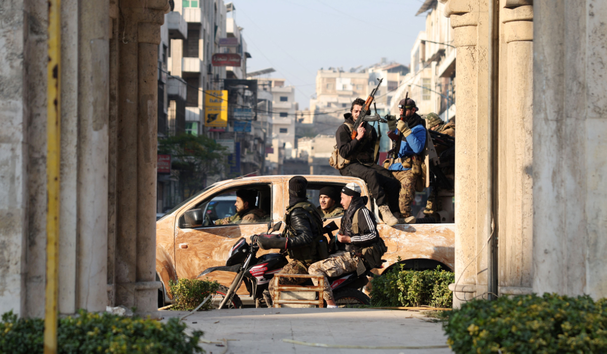 Anti-government fighters patrol the streets of Hama after they captured the central Syrian city, on December 6, 2024. (AFP)