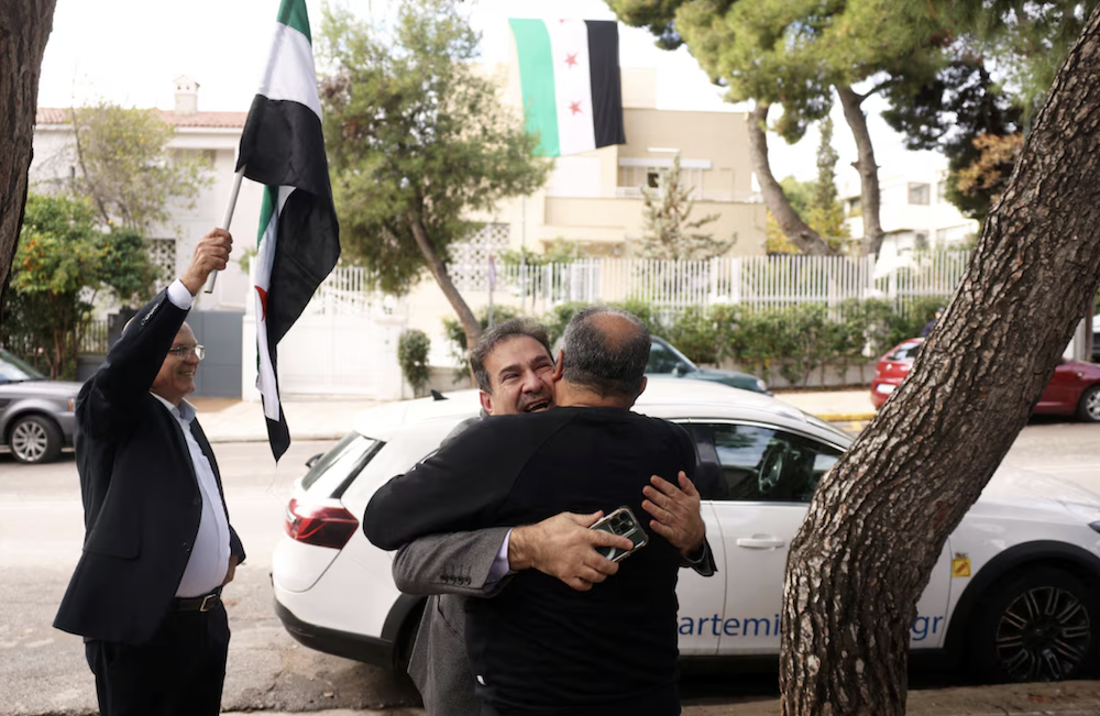 Supporters of militants who ousted President Bashar Assad on Sunday have entered some Syrian embassies abroad to hoist their flag, as seen here in Greece. (Reuters)
