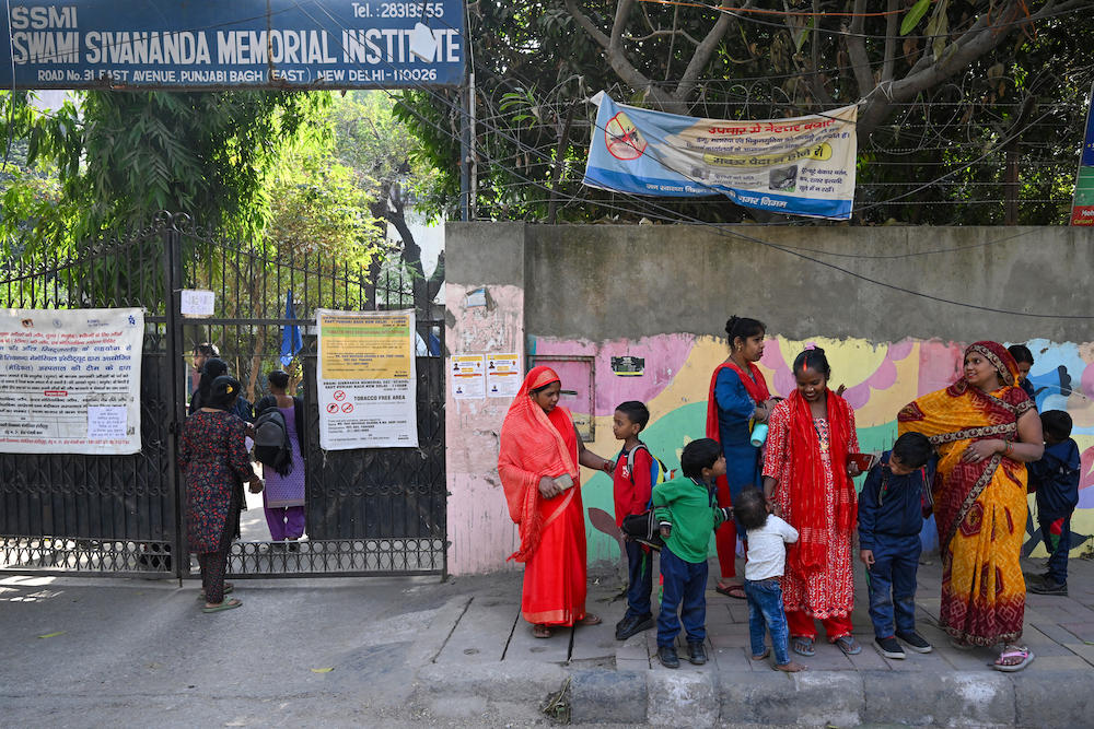 Above, parents collect their children from a New Delhi school. At least 40 schools received a bomb threat by email in Delhi on Monday demanding $30,000, ANI news agency said. (AFP file photo)