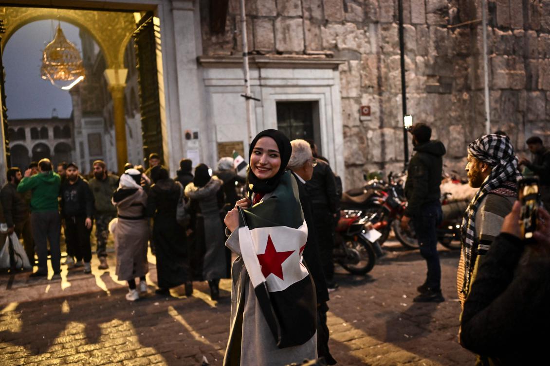 A woman poses outside the Ummayad mosque in the old city of Damascus on Dec. 11, 2024, after a lightning offensive ousted president Bashar Assad. (AFP)