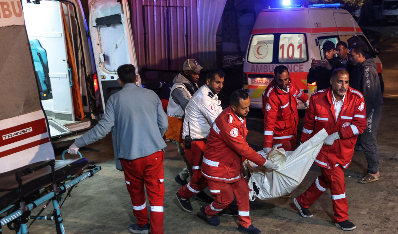 Palestinian Red Crescent rescuers carry the victim of an Israeli strike into Nasser Hospital in Khan Yunis in the south Gaza Strip, early on December 12, 2024. (AFP)