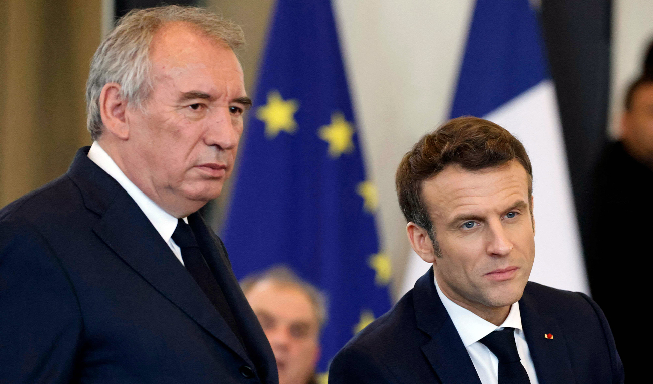 French President Emmanuel Macron (R) and French President of the Modem party Francois Bayrou (L) react during a meeting with citizens at the Palais Beaumont in Pau, southwestern France, on March 18, 2022, as part of the political campaign ahead of the presidential election in France. (AFP/File)