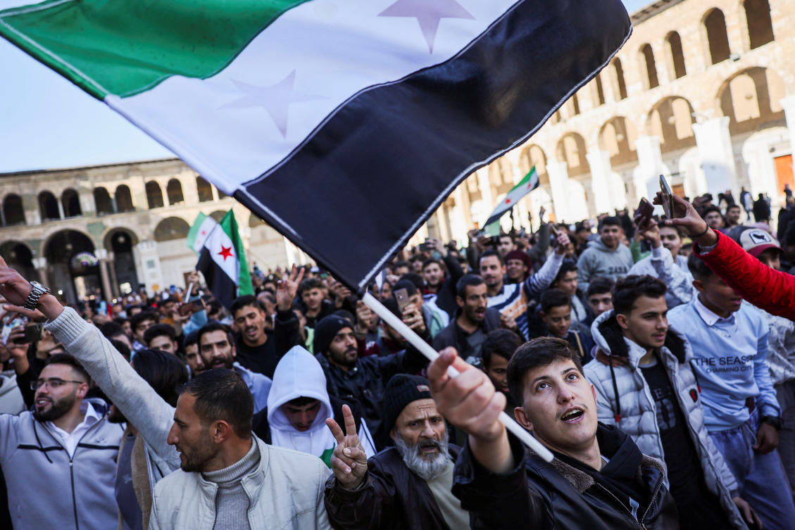 People walk with flags before the first Friday prayers at the Umayyad Mosque, after fighters of the ruling Syrian body ousted Syria’s Bashar Assad, in the Damascus old city, Dec. 13, 2024. (Reuters)
