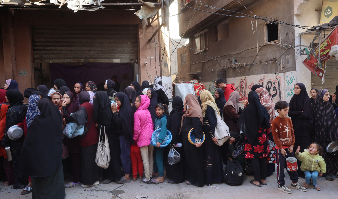 Palestinians wait for food aid outside a distribution centre at the Nuseirat refugee camp in the central Gaza Strip on December 4, 2024. (AFP)