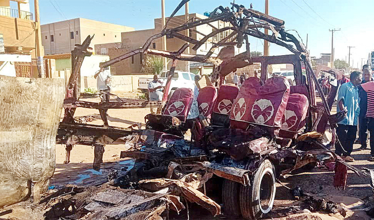 People gather near a destroyed vehicle in Omdurman, Sudan. (File/Reuters)