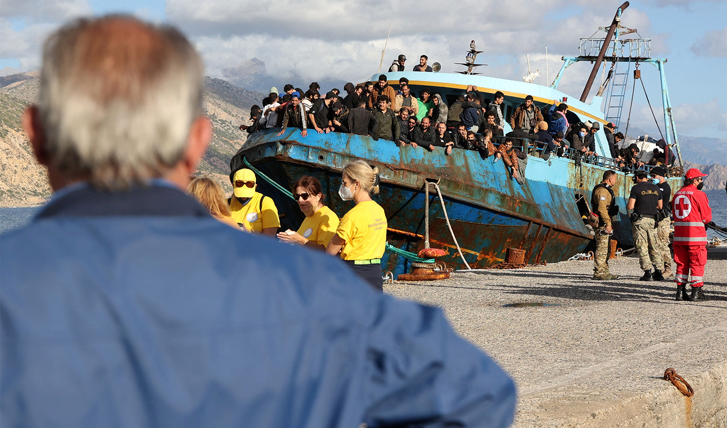 Rescued refugees and migrants stand aboard a boat at the town of Paleochora, southwestern Crete island on November 22, 2022. (AFP/File)