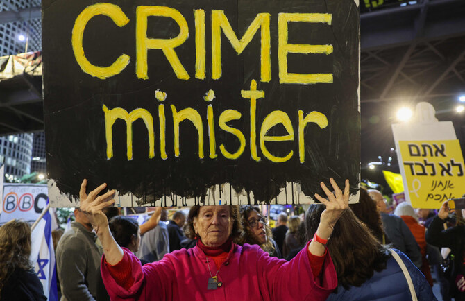 Demonstrators raise placards and Israeli flags during an anti-government protest calling for action to secure the release of Israeli hostages held captive since the October 2023 in the Gaza Strip, in front of the Israeli Defence Ministry in Tel Aviv on December 14, 2024. (AFP)