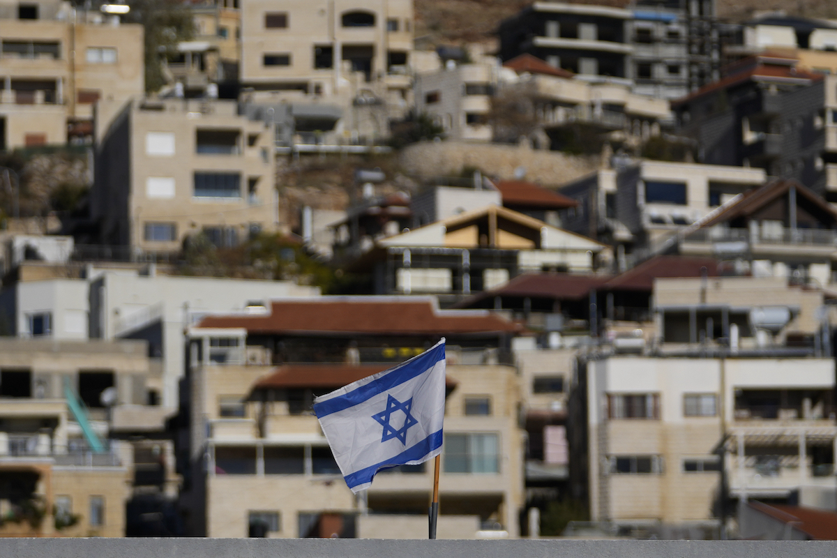 An Israeli flag flies on a roof in the town of Majdal Shams, near the so-called Alpha Line that separates the Israeli-controlled Golan Heights from Syria, Sunday, Dec. 15, 2024. (AP)