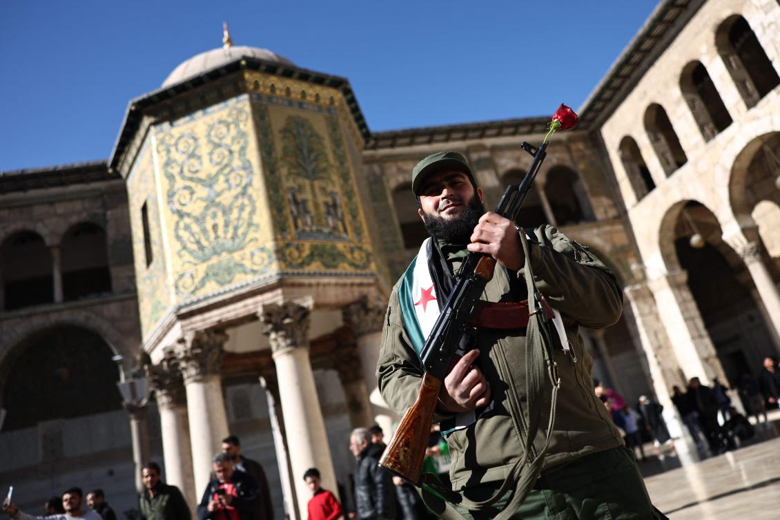 A fighter poses for a picture ahead of Syria’a Hayat Tahrir Al-Sham (HTS) group leader’s speech at the capital’s landmark Umayyad Mosque on December 13, 2024. (AFP)