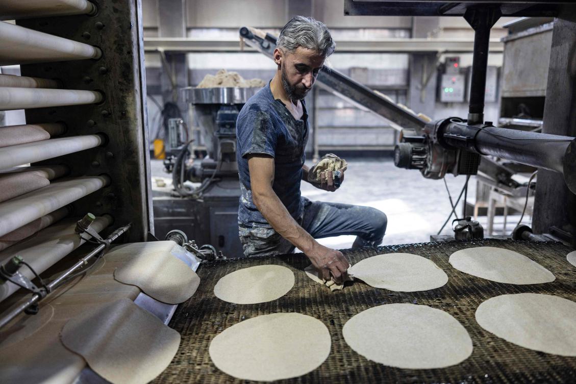 A worker prepares flatbread at a bakery in the Syrian town of Douma on the outskirts of the capital Damascus on December 15, 2024. (AFP)