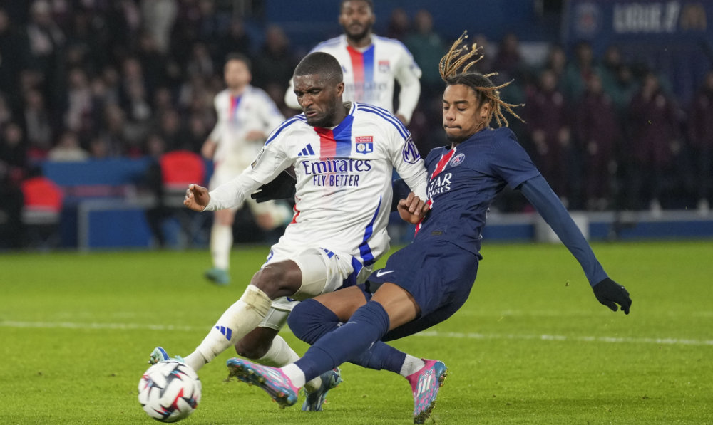 Lyon's Ainsley Maitland-Niles, left, challenges PSG's Bradley Barcola during the French League One soccer match between Paris Saint-Germain and Lyon at the Parc des Princes in Paris, Sunday, Dec. 15, 2024. (AP)