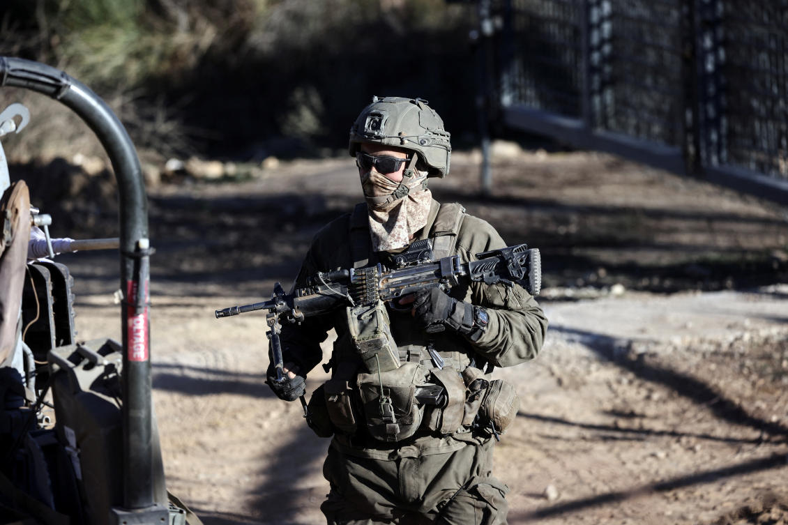 An Israeli soldier stands by the ceasefire line between the Israeli-occupied Golan Heights and Syria, as seen from Majdal Shams in the Golan Heights, December 15, 2024. (Reuters)