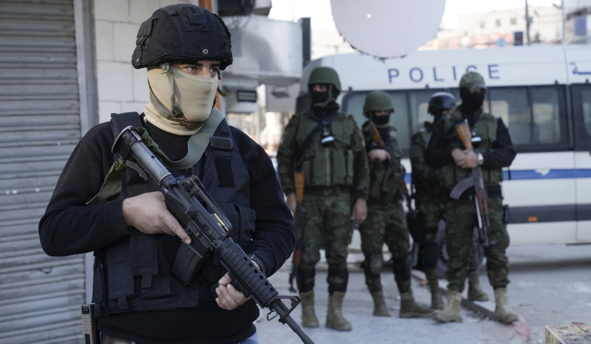 A officer from the Palestinian Authority clutches his gun as Palestinian security forces mount a major raid against militants in the Jenin refugee camp in the Israeli-occupied West Bank, Monday, Dec. 16, 2024. (AP)
