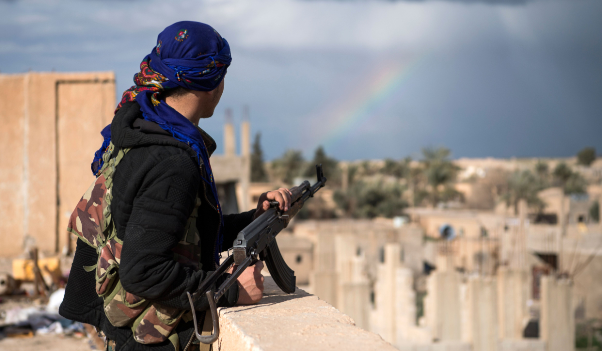 A member of the Syrian Democratic Forces (SDF) stands guard on top of a building on February 17, 2019, in the frontline Syrian village of Baghuz. (AFP)