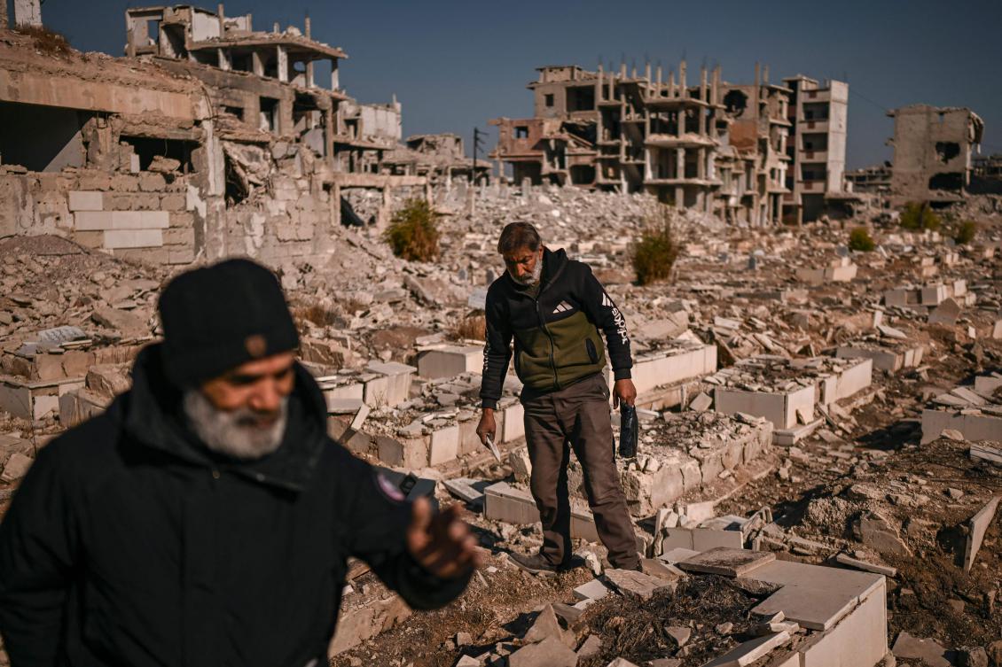 People look for the graves of relatives in a damaged cemetery at the Yarmouk camp for Palestinian refugees in the south of Damascus on December 14, 2024. (AFP)