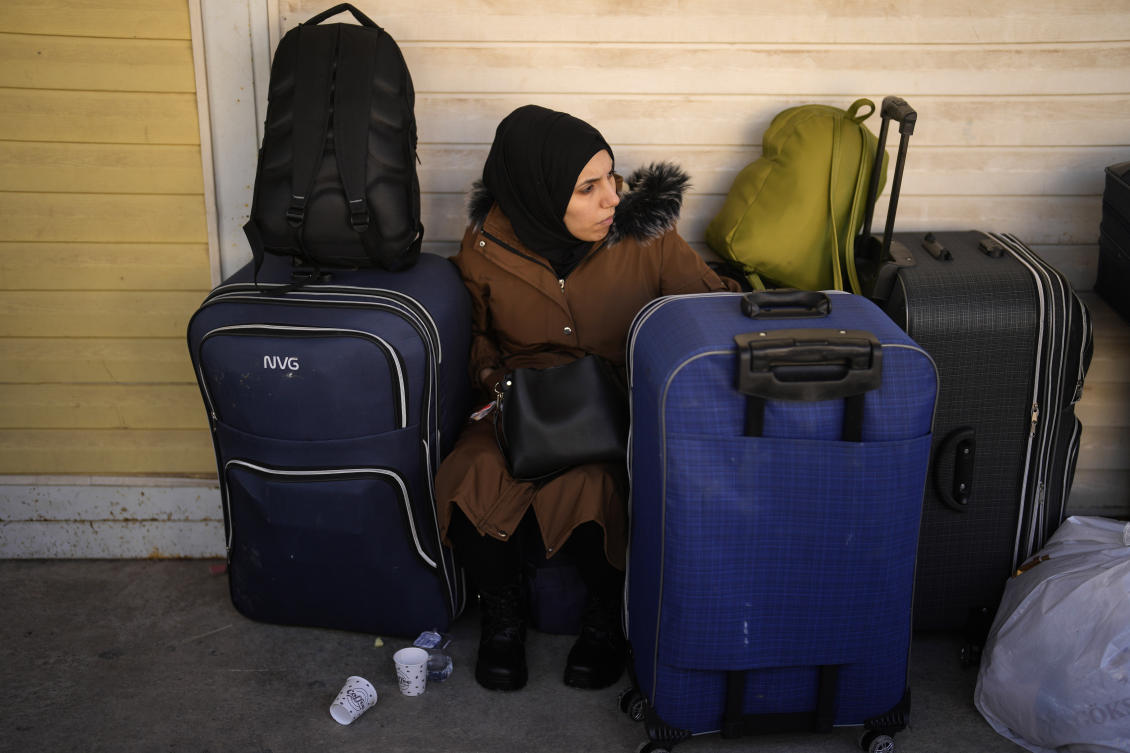 A Syrian woman rests next to her belongings as she waits to cross into Syria from Turkey at the Oncupinar border gate, near the town of Kilis, southern Turkey, Tuesday, Dec. 17, 2024. (AP)