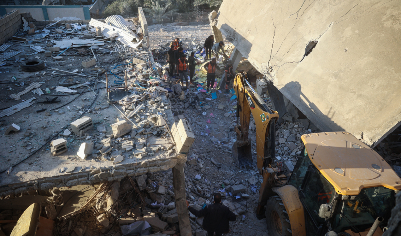 Rescuers and people search the rubble for casualties following an Israeli strike on the municipality building in Deir El-Balah in the central Gaza Strip on December 14, 2024. (AFP)