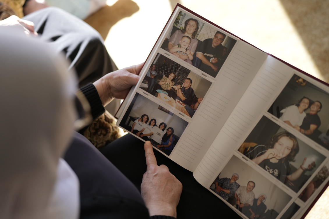 Samar Safadi looks at family photos after speaking by phone with her sister, Sawsan, who lives inside the buffer zone near the ‘Alpha Line’ that separates the Israeli-controlled Golan Heights from Syria, in the town of Majdal Shams on Dec. 18, 2024. (AP)