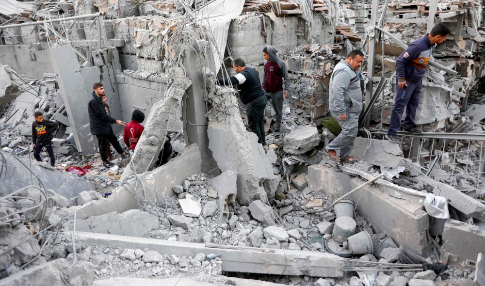 People inspect the damage following an Israeli strike on a home in the Al-Daraj neighborhood in Gaza City. (Reuters)