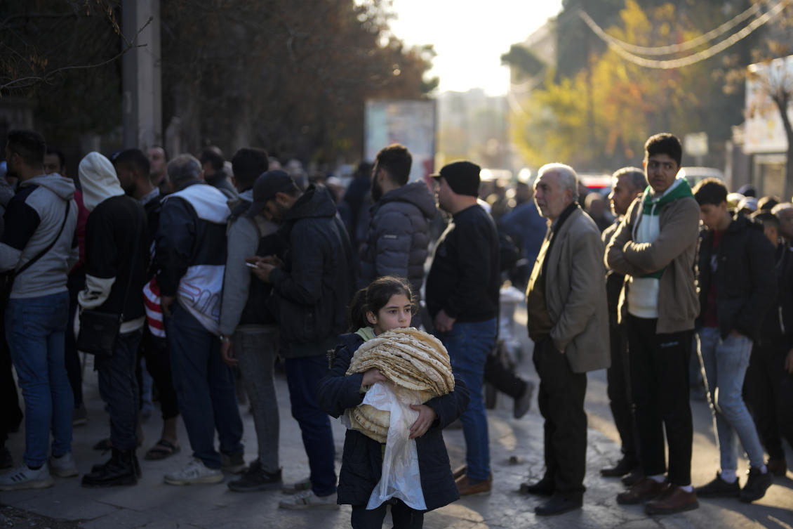 Residents stand in line to buy bread from a bakery in Aleppo, Syria. (File/AP)