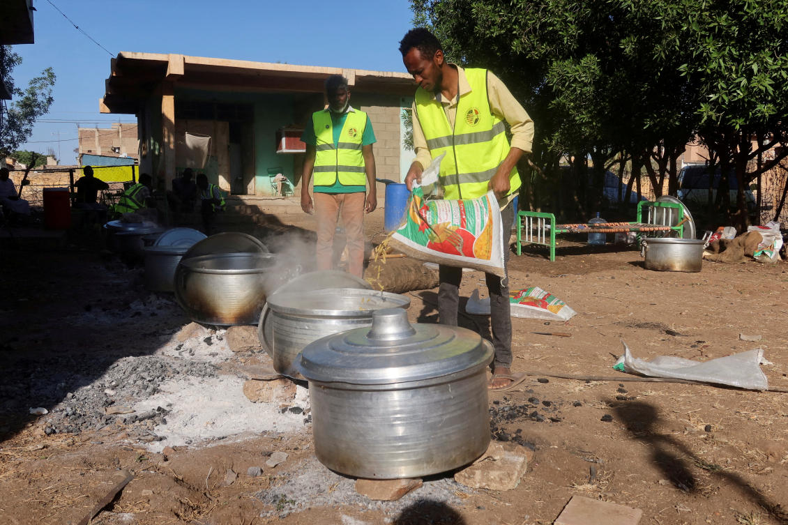 Volunteer at a Sudanese mobile kitchen prepares food at one of the displacement centers in New Halfa, Sudan. (File/Reuters)