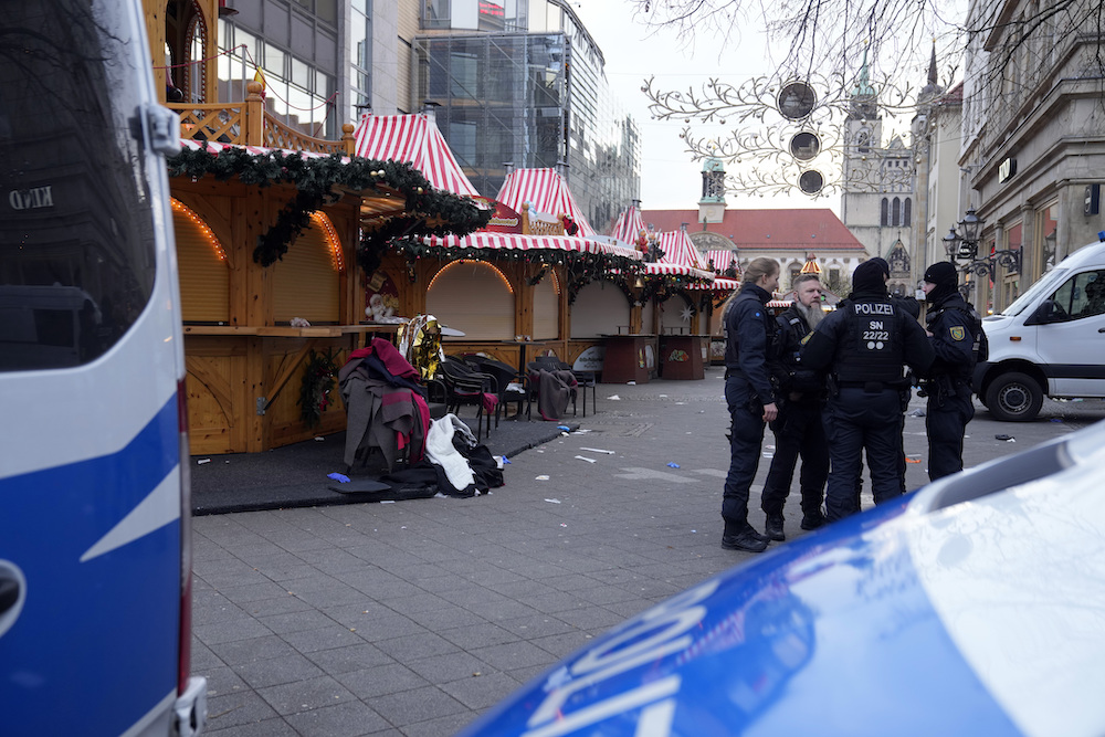 Police officers stand at a cordoned-off Christmas Market, where a car drove into a crowd on Friday evening, in Magdeburg, Germany on Dec. 21, 2024. (AP)