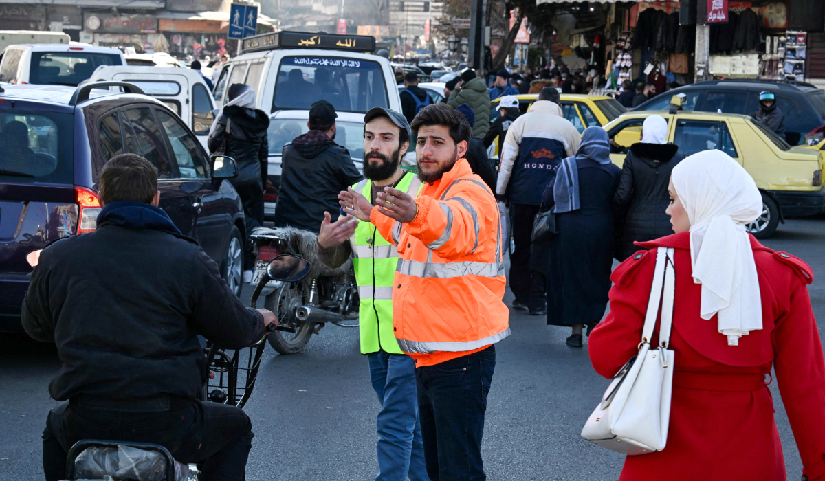 Syrian volunteers help police regulate traffic in Damascus on December 19, 2024. (AFP)