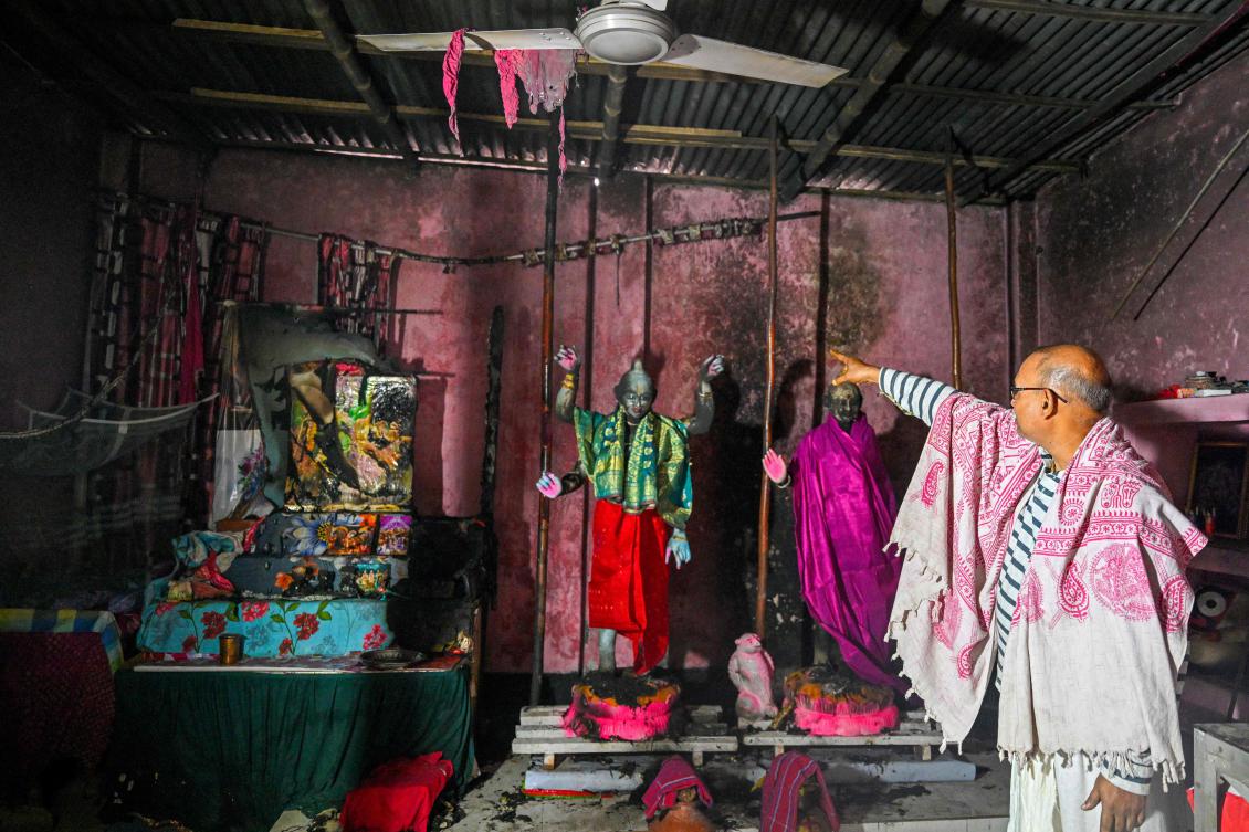 Above, the Laxmi-Narayan temple’s custodian Ratan Kumar Ghosh shows burnt idols of Hindu deities, on the outskirts of Dhaka. (AFP)