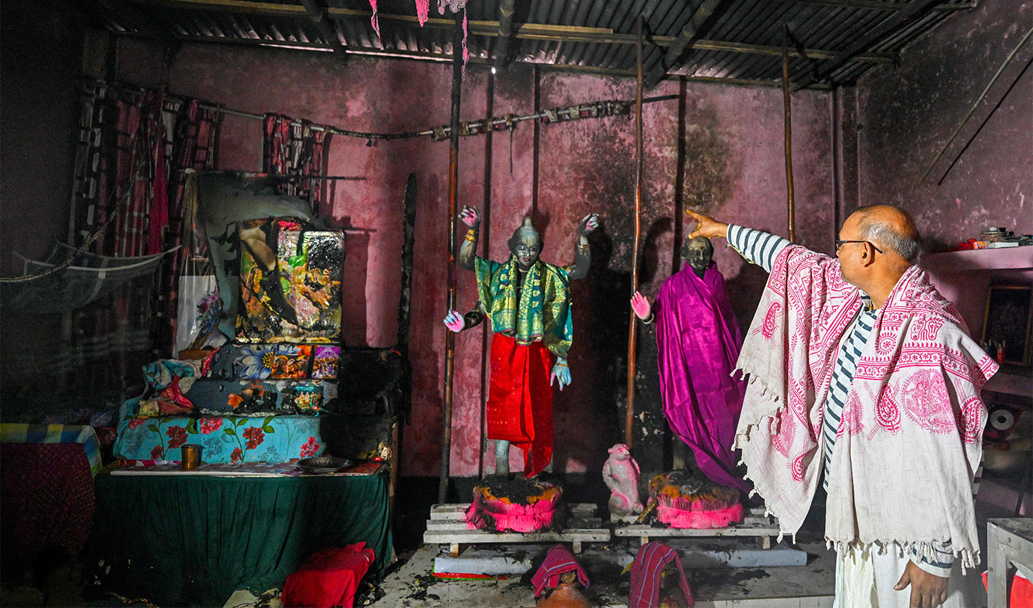 In this photograph taken on December 9, 2024, the Laxmi-Narayan temple's custodian Ratan Kumar Ghosh shows burnt idols of Hindu deities, on the outskirts of Dhaka. (AFP)