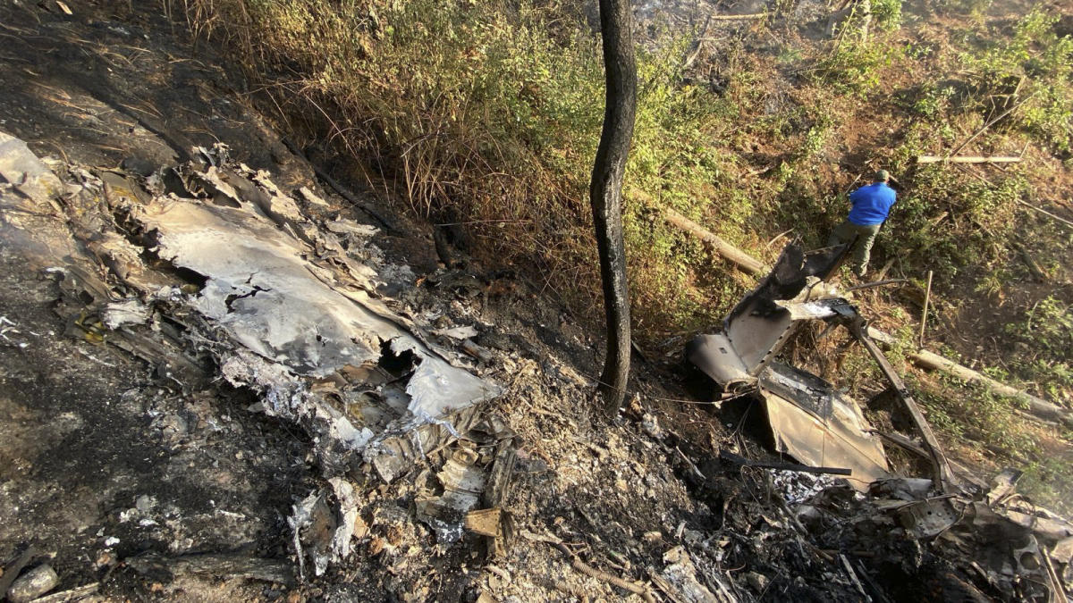 Above, a resident looks at the site where a Cessna 207 plane crashed in Santa Maria del Oro, Jalisco state, Mexico on Dec. 22, 2024. (Proteccion Civil Jalisco/AFP)