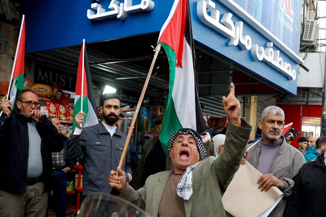 People hold Palestinian flags during a demonstration against the Jenin camp shooting between Palestinian security forces and militants, in Jenin, Israeli-occupied West Bank, December 21, 2024. (REUTERS)