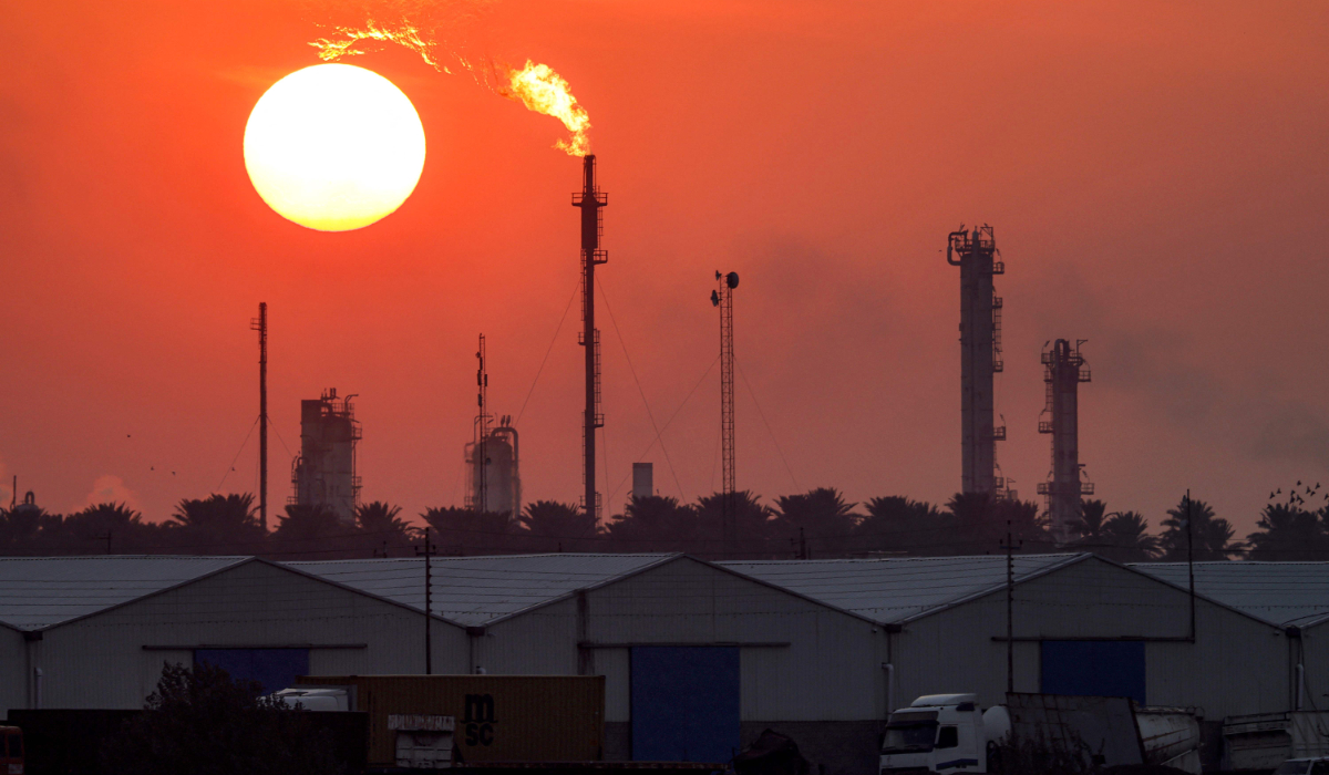 The sun sets behind burning gas flares at the Dora (Daura) Oil Refinery Complex in Baghdad on December 22, 2024. (AFP)