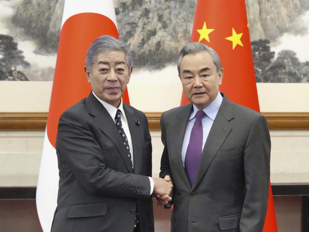 Japan’s Foreign Minister Takeshi Iwaya, left, and Chinese Foreign Minister Wang Yi, right, shake hands in Beijing’s Diaoyutai State Guesthouse Wednesday, Dec. 25, 2024. (AP)