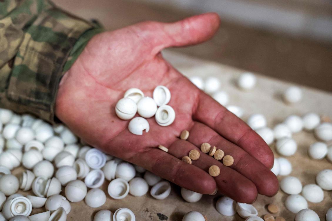 A Syrian rebel fighter inspects pills of Captagon (brand name of psychostimulant drug Fenethylline) produced at a makeshift lab facility at a ranch villa in the town of Al-Dimas about 27 kilometers northwest of Damascus on December 22, 2024. (AFP)