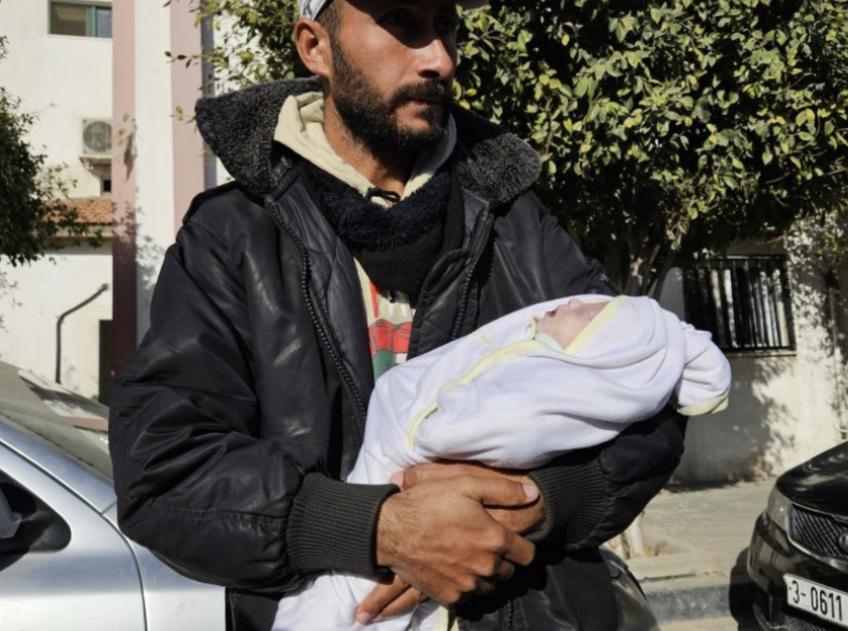The father of Sila, Mahmoud Al-Faseeh, wrapped her in a blanket to try and keep her warm in their tent in the Muwasi area, but it wasn’t enough. (Getty Images)