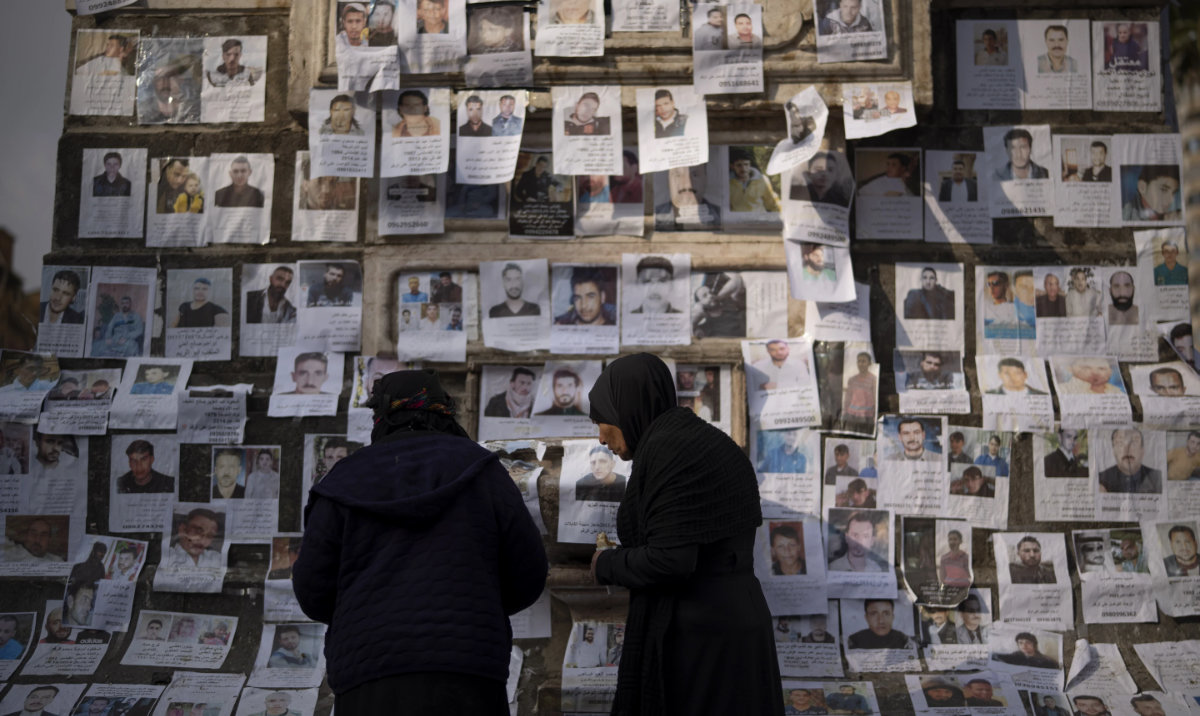 Women look at photos of people reported to be missing by members of ousted Syrian President Bashar Assad‘s army, or a pro-government militia, in the Marjeh square in Damascus, Syria, Sunday, Dec. 22, 2024. (AP)
