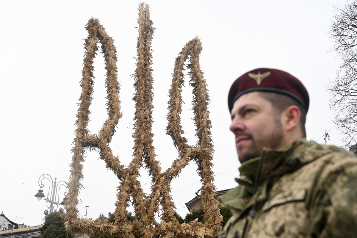 A Ukrainian paratrooper of the 80th Separate Galician Air Assault Brigade takes a part in the presentation of a 7.5-metre Trident, a Ukrainian national symbol, made of 'didukh' in Lviv on December 23, 2024, amid the Russian invasion of Ukraine. (AFP)
