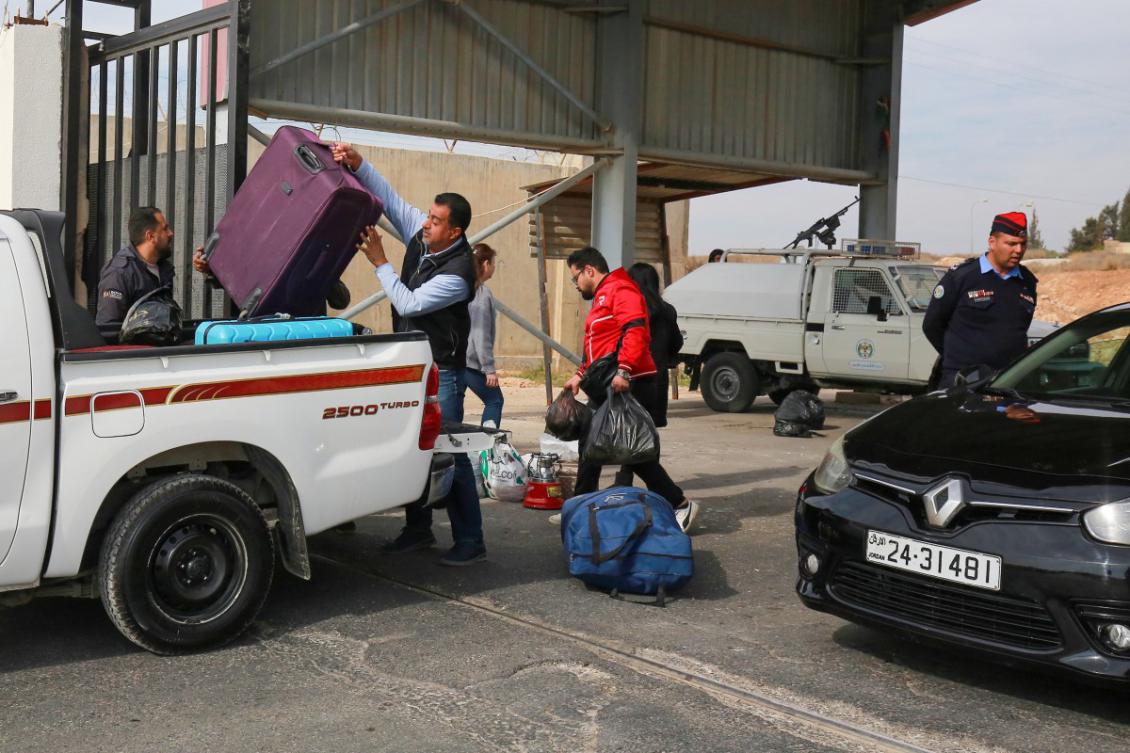 Syrians wait to cross through Jordan's Jaber crossing and into Syria on December 8, 2024, following the fall of the Syrian regime in Damascus. Jordanian police officers check the documents of Syrians returning to their country through the ـJaber border crossing on December 8, 2024. (AFP)