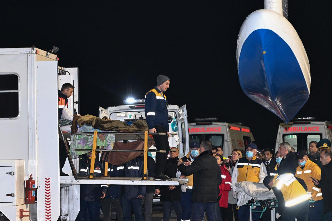 Airport ground staff assist Azerbaijani citizens, who survived the crash of the Azerbaijan Airlines’ Embraer 190 passenger jet near the western Kazakh city of Aktau, upon arrival at Baku’s Heydar Aliyev International Airport on December 26, 2024. (AFP)