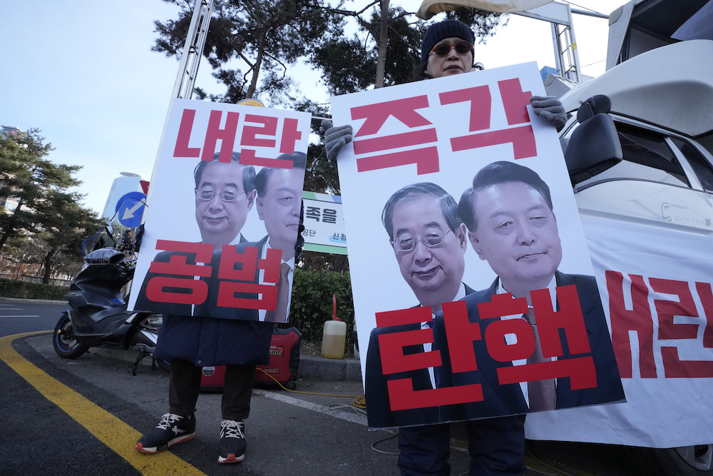 Protesters hold banners showing images of impeached President Yoon Suk Yeol, right, and acting President Han Duck-soo during a rally in Seoul, South Korea on Dec. 27, 2024. (AP)
